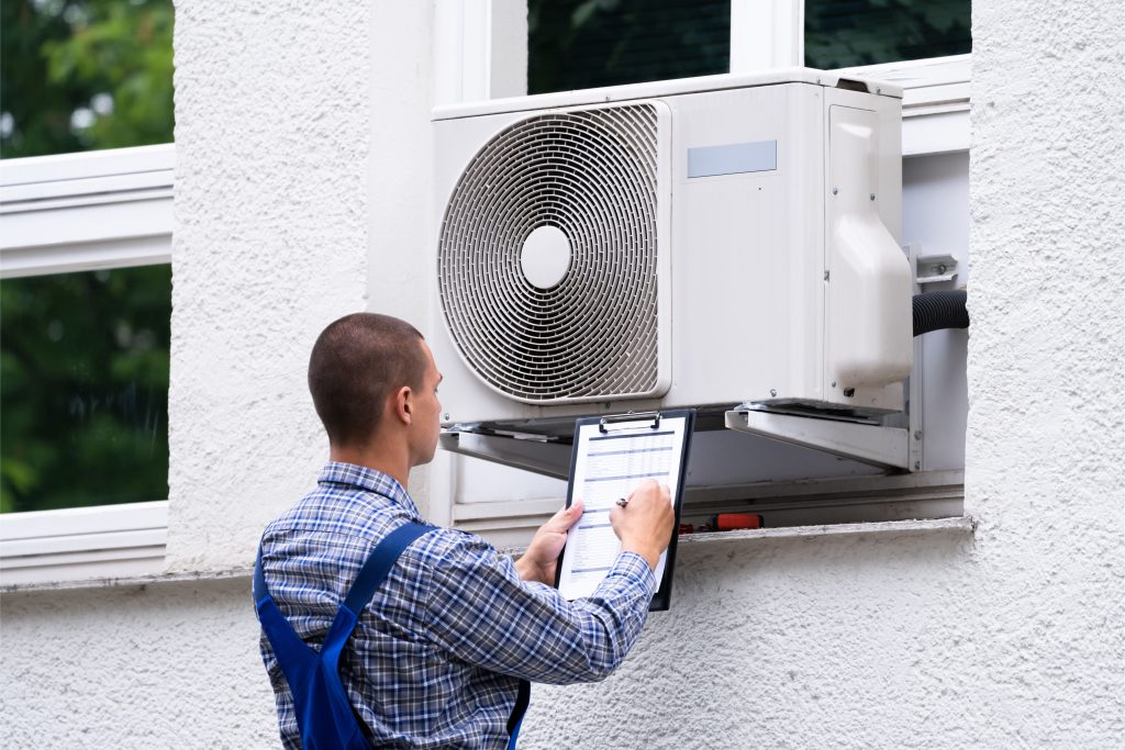 An HVAC technician working on an AC unit