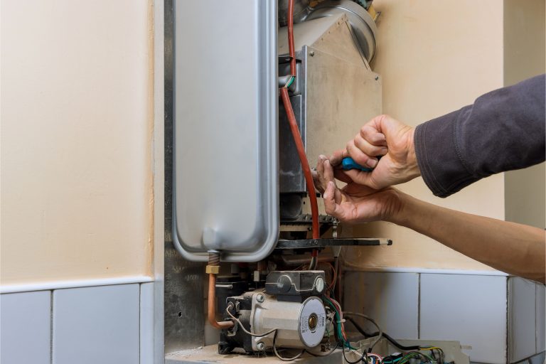 Technician performing emergency heating repair on a residential heating system