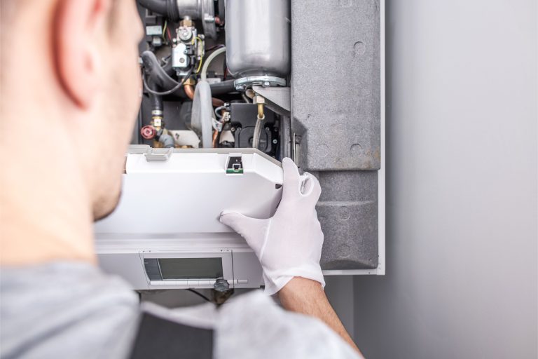 Technician performing emergency heating repair on a furnace