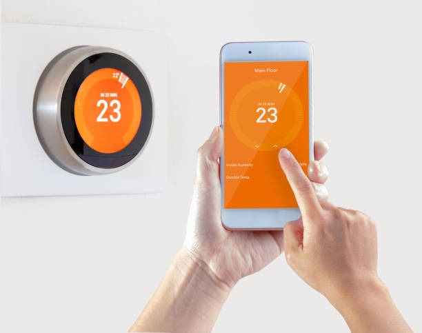 Smart thermostat with a digital display and modern design, showing temperature settings and controls.