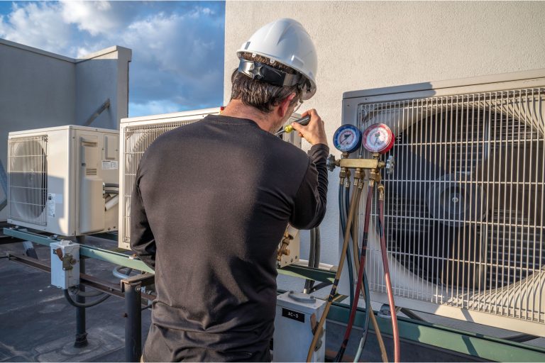 Technician performing HVAC repair on a residential air conditioning unit.