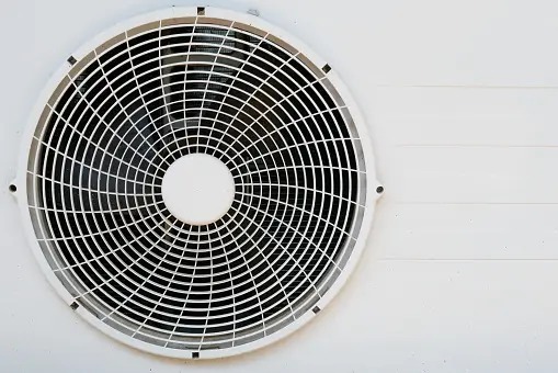 Close-up of a condenser coil in an HVAC system, showcasing its metal fins and tubing