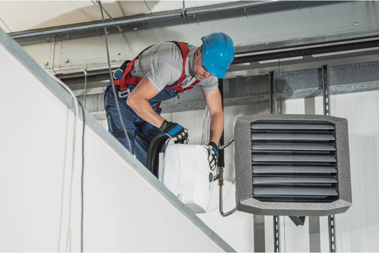 Technician performing HVAC heater installation in a residential home.