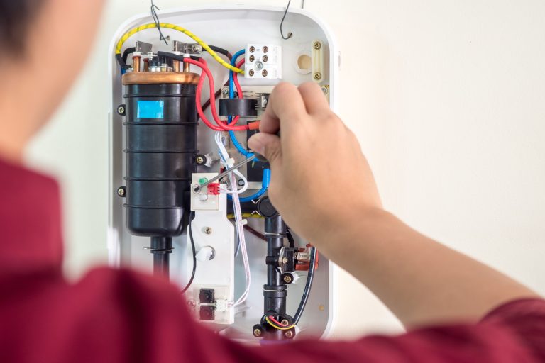 Technician performing water heater repair service, fixing the tank and checking connections to ensure proper functioning