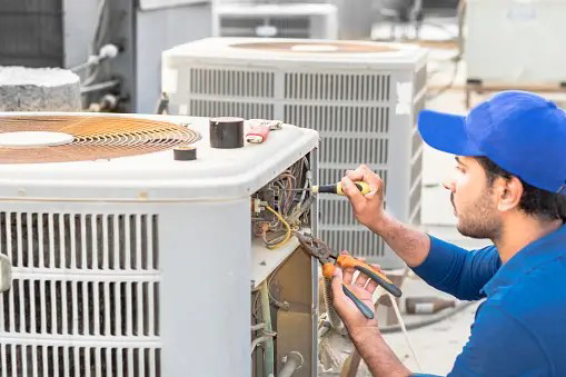 An HVAC contractor working on an HVAC unit